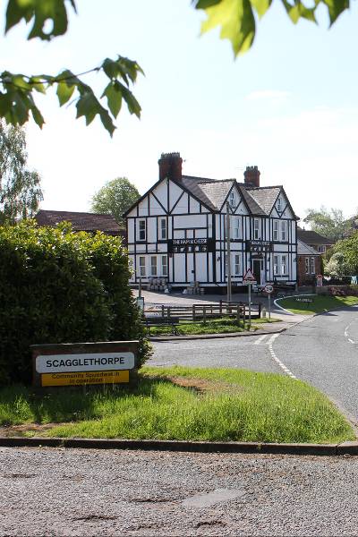 entrance to the village with scagglethorpe sign and a pub in the distance